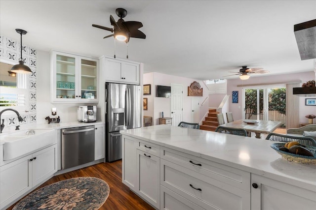 kitchen with light stone counters, dark hardwood / wood-style flooring, white cabinets, and appliances with stainless steel finishes