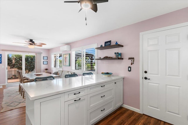 kitchen featuring plenty of natural light, dark hardwood / wood-style floors, white cabinetry, and a wall mounted AC