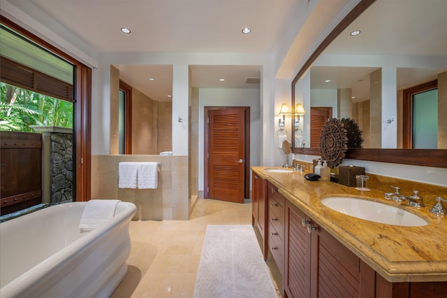 bathroom featuring tile patterned flooring, vanity, and a tub to relax in