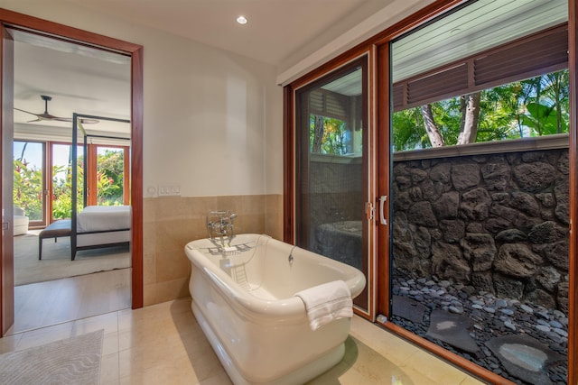 bathroom with wood-type flooring, tile walls, and a tub