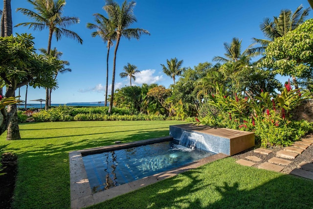 view of pool with a lawn and pool water feature