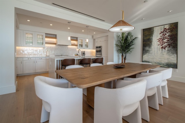 dining area with light hardwood / wood-style flooring and sink