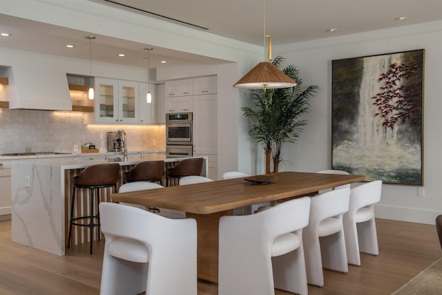 dining room featuring light wood-type flooring and sink