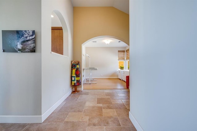 hall featuring lofted ceiling