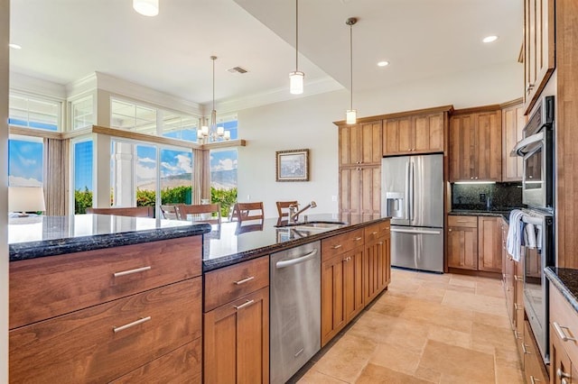 kitchen featuring decorative backsplash, sink, dark stone countertops, pendant lighting, and stainless steel appliances