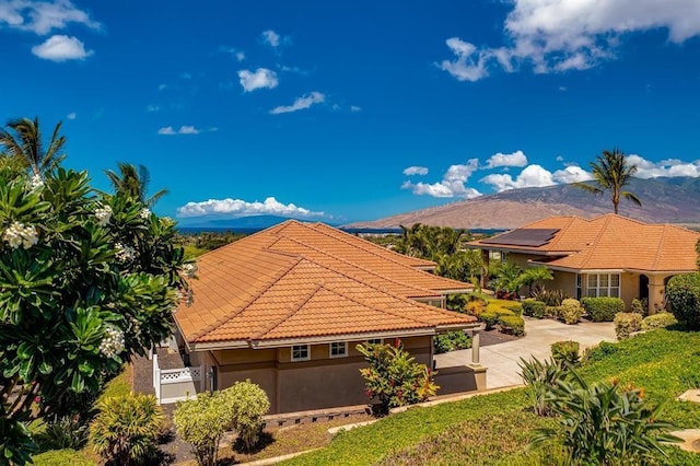 exterior space with a mountain view and solar panels