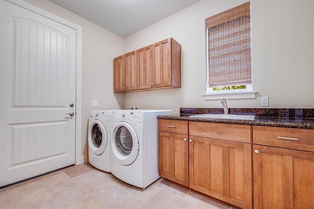 laundry area with sink, washing machine and clothes dryer, and cabinets