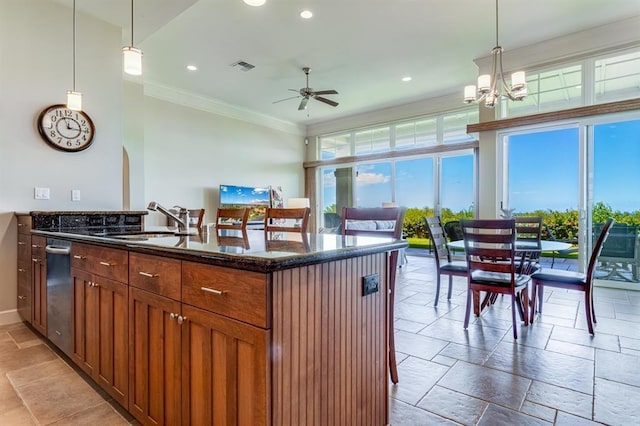 kitchen with sink, dark stone countertops, ornamental molding, and pendant lighting