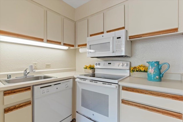 kitchen with sink, white cabinets, and white appliances