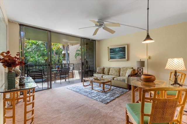 living room featuring expansive windows, carpet, and ceiling fan