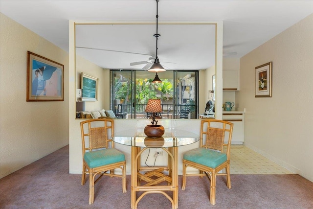 dining room with ceiling fan and light carpet