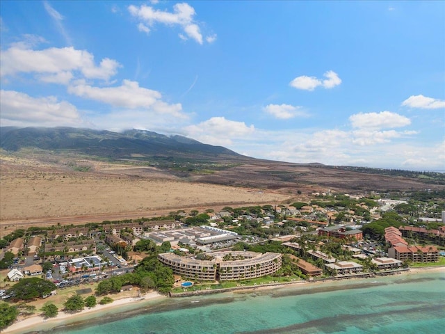 birds eye view of property featuring a water and mountain view and a view of the beach