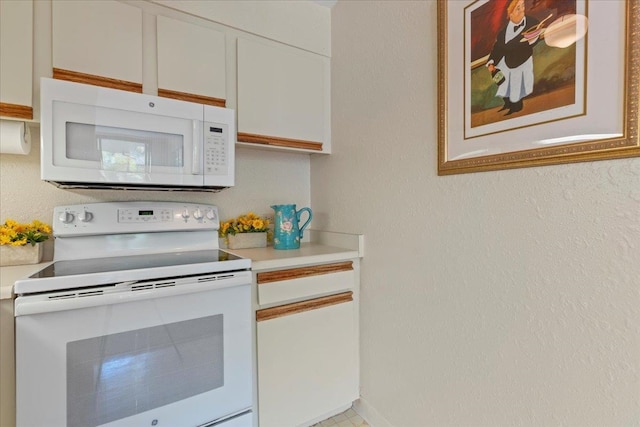 kitchen with white cabinetry and white appliances