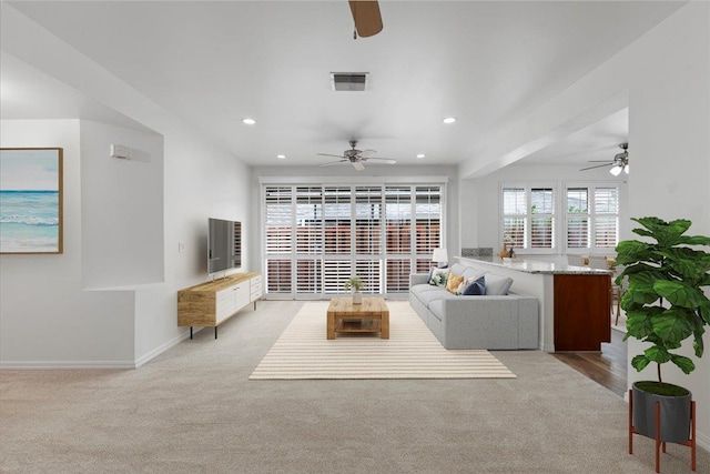 carpeted living room featuring ceiling fan