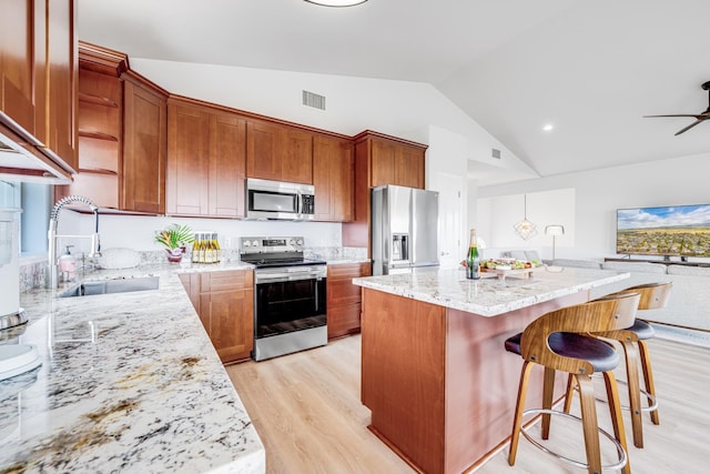 9 Fern Pl, Lahaina, HI 96761 - kitchen featuring a breakfast bar area, appliances with stainless steel finishes, vaulted ceiling, a sink, and light wood-style flooring