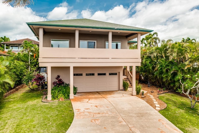 9 Fern Pl, Lahaina, HI 96761 - view of front of home featuring stucco siding, concrete driveway, a balcony, and a garage