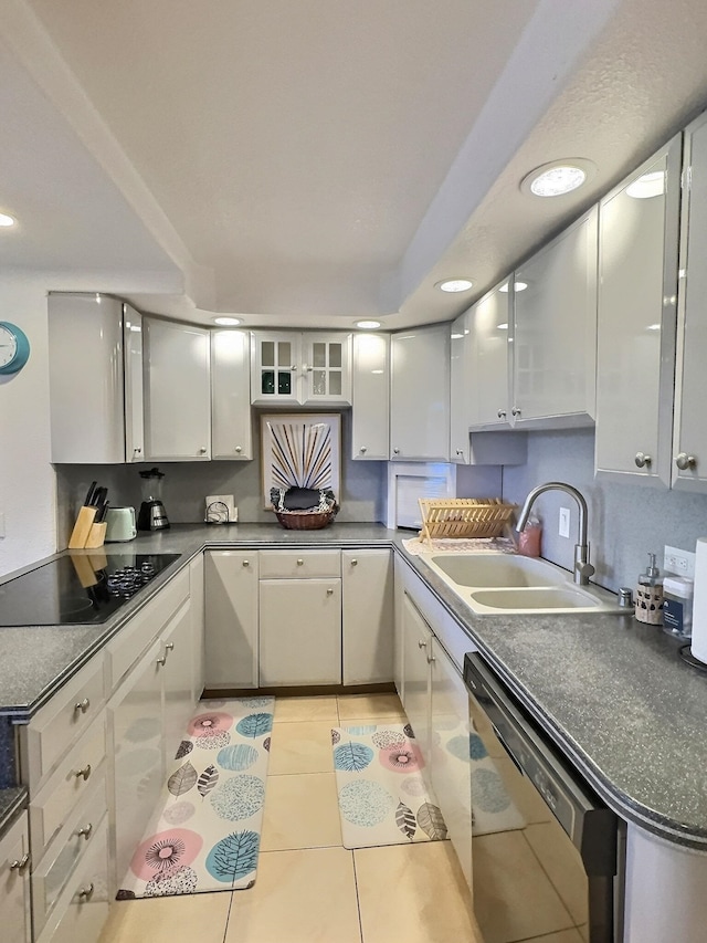 kitchen featuring white cabinetry, light tile flooring, black electric stovetop, and stainless steel dishwasher