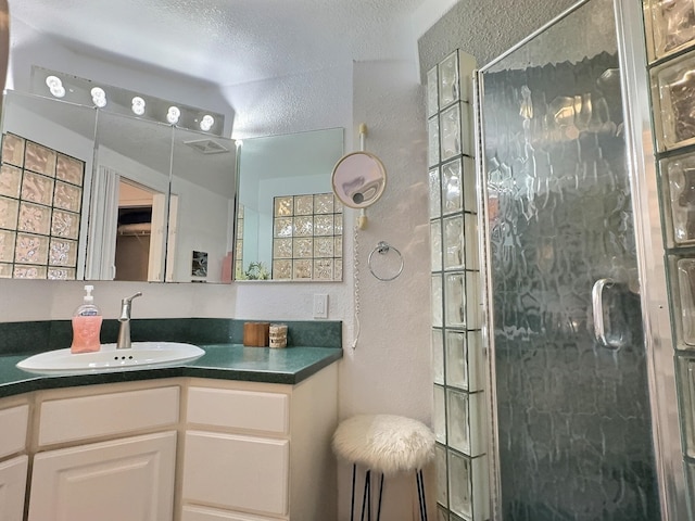 bathroom featuring an enclosed shower and vanity