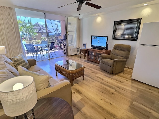 living room featuring ceiling fan and light hardwood / wood-style flooring