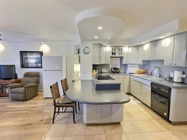 kitchen featuring light hardwood / wood-style flooring, kitchen peninsula, sink, and black appliances