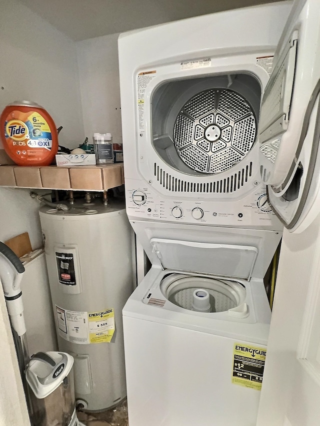 laundry room featuring electric water heater and stacked washer / dryer