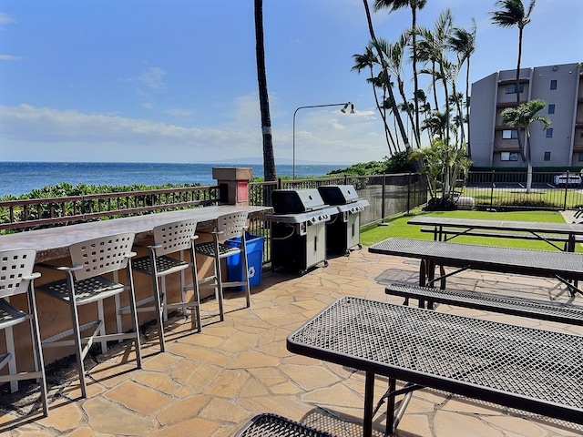 view of patio featuring area for grilling and a water view