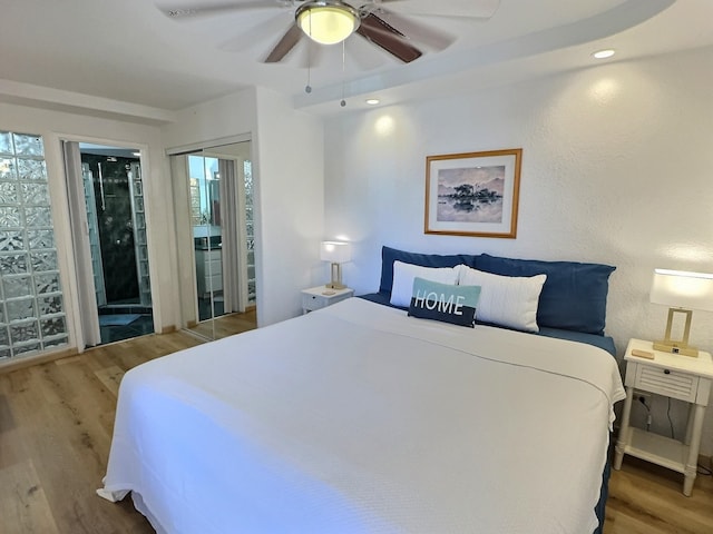 bedroom with wood-type flooring, ceiling fan, and ensuite bathroom