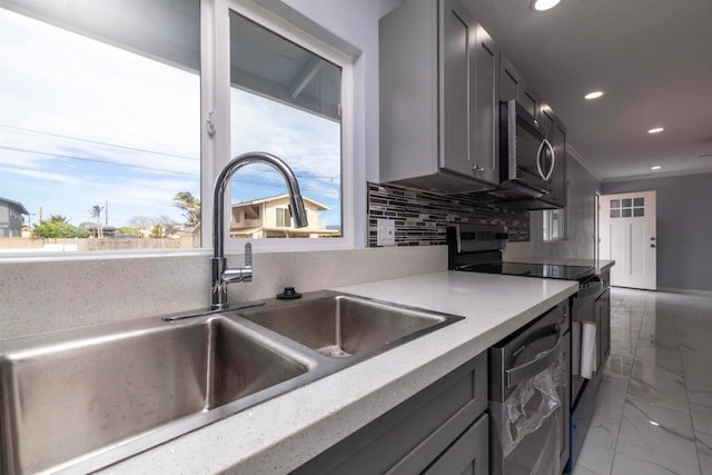 kitchen with decorative backsplash, appliances with stainless steel finishes, sink, and gray cabinetry