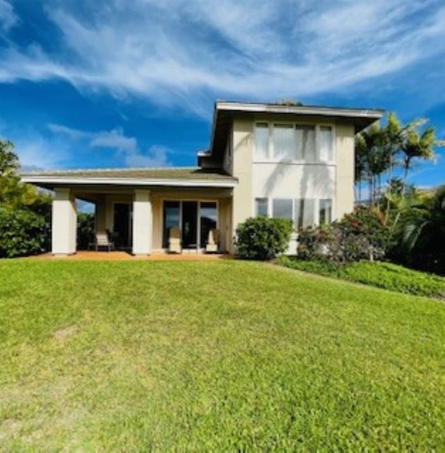 rear view of property featuring a lawn