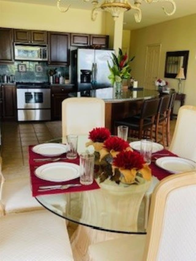 dining room with tile patterned flooring and a chandelier