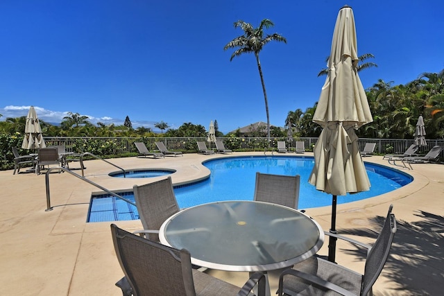 pool with outdoor dining space, a patio area, fence, and a hot tub