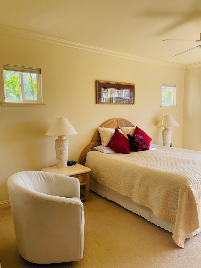 bedroom featuring ceiling fan, crown molding, and carpet flooring