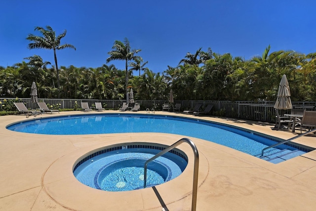 view of swimming pool with a patio area and a hot tub