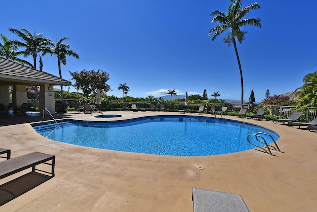 view of swimming pool featuring a community hot tub and a patio