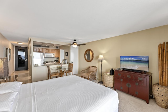 bedroom featuring light carpet, refrigerator, and ceiling fan