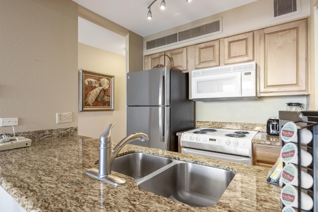 kitchen with kitchen peninsula, light brown cabinetry, white appliances, and sink