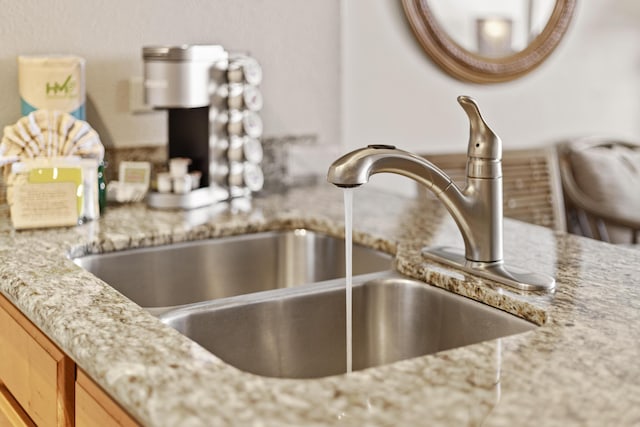 interior details with light stone countertops, sink, and light brown cabinetry