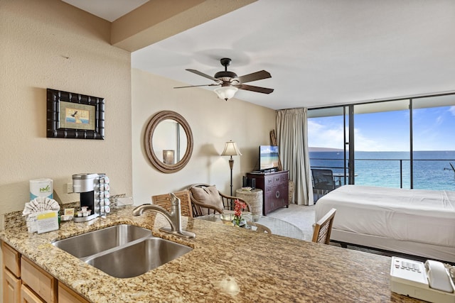 bedroom featuring access to exterior, ceiling fan, and sink