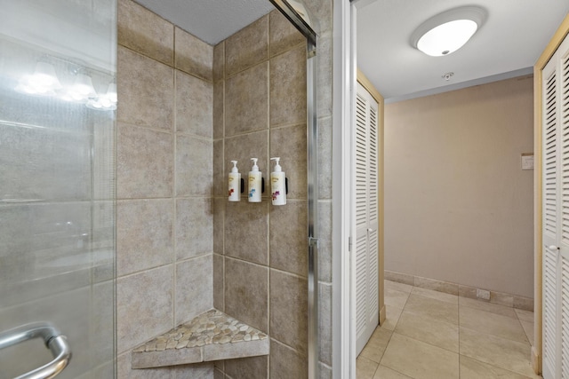 bathroom with tile patterned floors and a shower with shower door