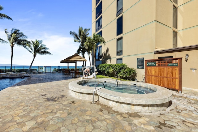 view of swimming pool with a gazebo and a water view