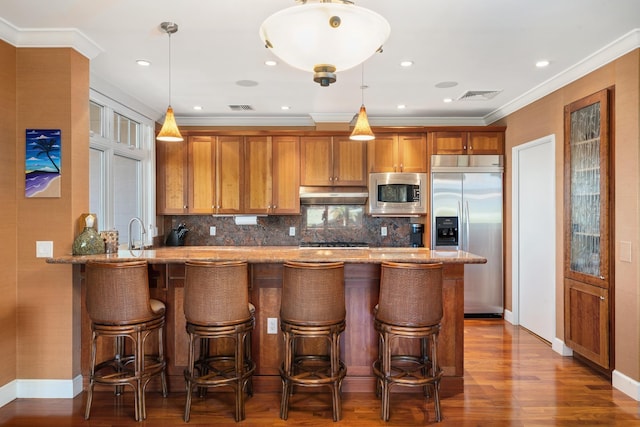 161 Wailea Ike Pl Unit D201, Kihei, HI 96753 - kitchen featuring built in appliances, under cabinet range hood, brown cabinetry, tasteful backsplash, and light stone counters