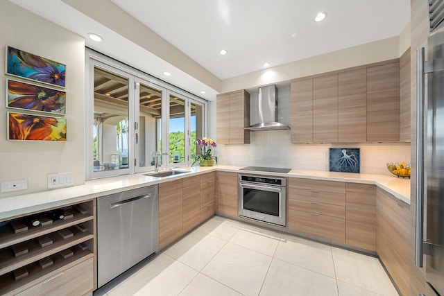 kitchen with wall chimney exhaust hood, sink, tasteful backsplash, light tile patterned floors, and stainless steel appliances