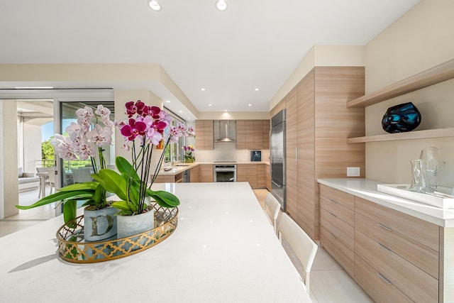 kitchen with backsplash, stainless steel appliances, light tile patterned floors, and wall chimney range hood