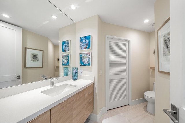 bathroom with tile patterned flooring, vanity, and toilet