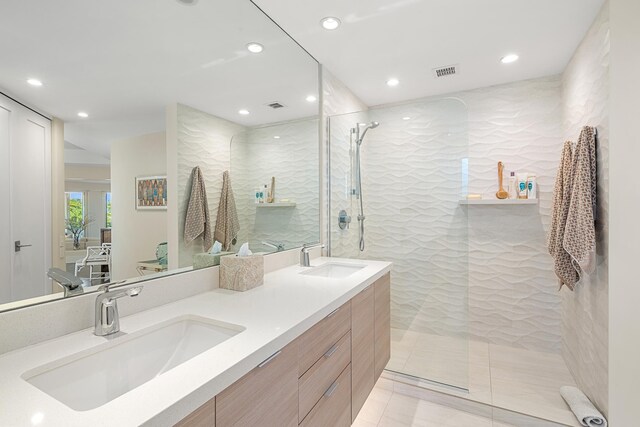 bathroom featuring tiled shower and vanity