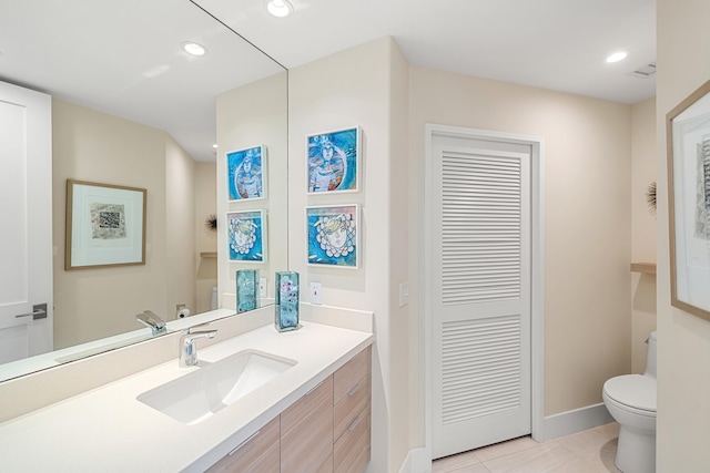 bathroom featuring vanity, tile patterned floors, and toilet