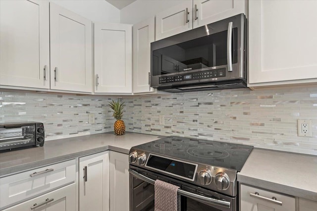 kitchen with decorative backsplash, white cabinetry, and stainless steel appliances