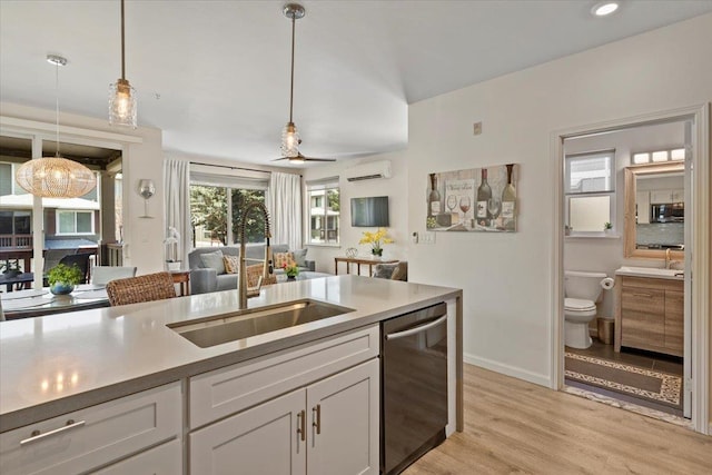 kitchen featuring light hardwood / wood-style floors, an AC wall unit, white cabinets, decorative light fixtures, and stainless steel appliances