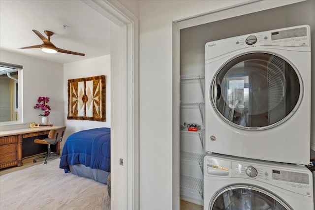 laundry room with ceiling fan and stacked washer / dryer