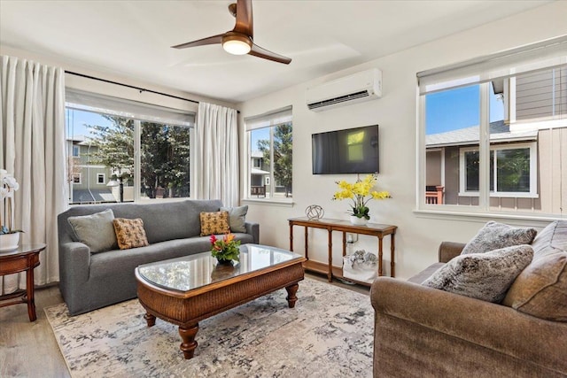 living room with ceiling fan, an AC wall unit, and wood-type flooring